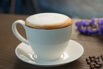 Hot cappuccino coffee on wood table.	