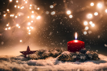 Kerze mit weihnachtlicher Dekoration im Schnee