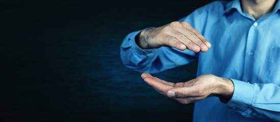 Man making protecting gesture on a blue background.