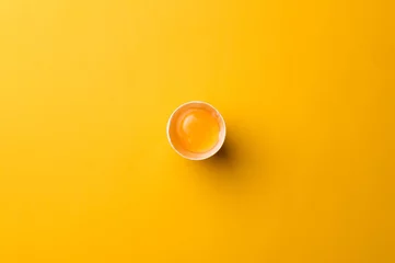  White egg and egg yolk on the yellow background. topview © masanyanka