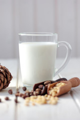 Cedar milk with pine nuts over white wooden table.