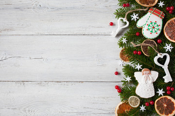 Christmas wood background with spruce branches, gingerbread, ornaments, berries, citrus fruits