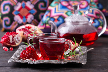 Fruit pomegranate tea in a teapot and cup