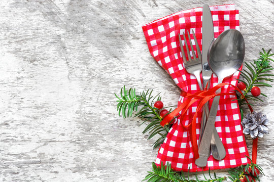 Christmas serving cutlery with napkin on white wooden background