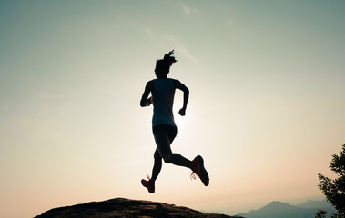 fitness woman runner running on sunrise mountain top edge