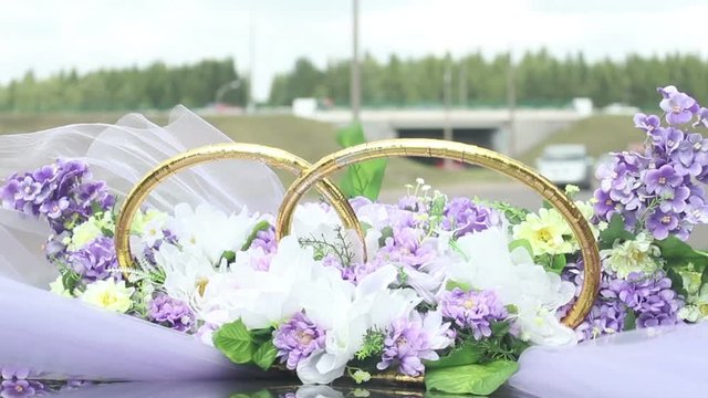 wedding bouquet of violet purle flowers blowing on wind on riding car, happy just married couple