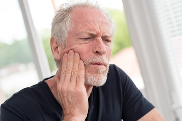 Portrait of mature man with toothache
