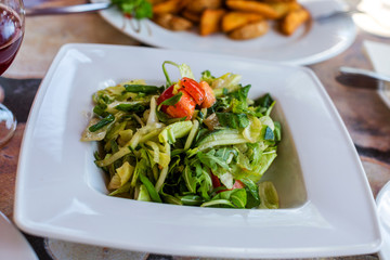 Salad with lettuce, cucumber, tomato, arugula in white bowl. Concept of healthy food