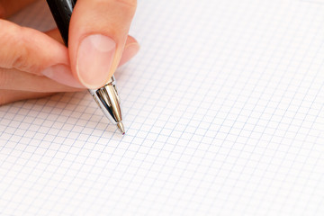 Female hand writes a pen in notebook