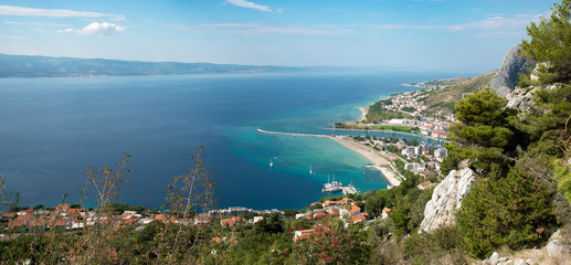 Fototapeta premium Widok na Omis z połowy drogi do Twierdzy Starigrad z rzeką Cetina, miasto, Morze Adriatyckie iw tle wyspę Brac.
