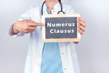 Arzt mit Schild Numerus Clausus zum Medizinstudium