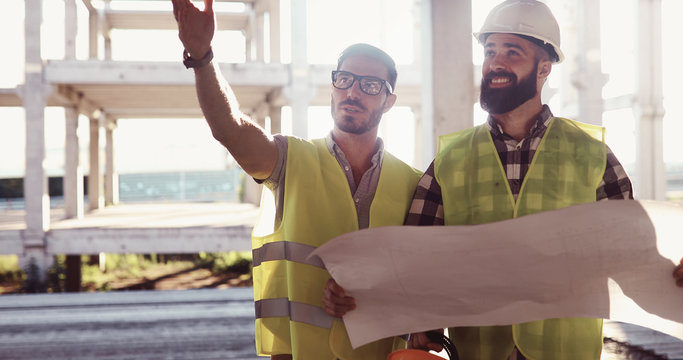 Construction engineers discussion with architects at construction site