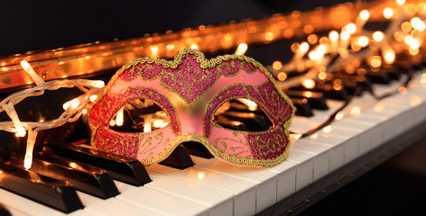 Carnival mask and lights on a piano keyboard