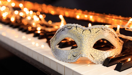 Carnival mask and lights on a piano keyboard