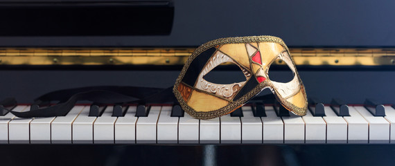 Carnival mask on piano keyboard, front view