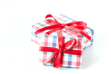 Two gift boxes in checked design wrapping paper tied with red ribbons, festive packaging mock up