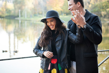 Beautiful couple walking in autumn park near a lake