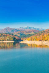     Panoramic view of Lokvarsko lake with Risnjak mountain in background, beautiful colorful mountain autumn landscape, Lokve, Gorski kotar, Croatia 
