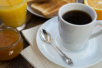 Breakfast: coffee, toasts, juice and jam on the wooden background