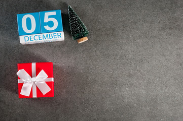December 5th. Image 5 day of december month, calendar with x-mas gift and christmas tree. New year background with empty space for text, mockup
