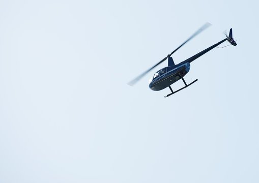 Small private helicopter in the sky.