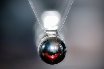 Newton's Cradle closeup, frontal shot, with out of focus background