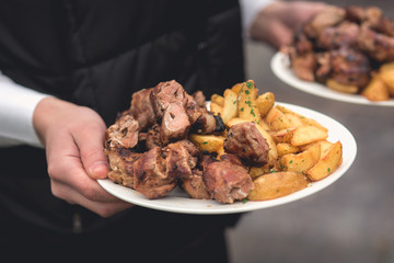 Anonymous person takes fried meat and potato