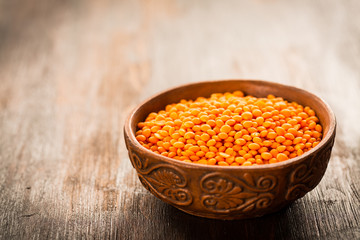 Red lentils in a bowl on old wooden table