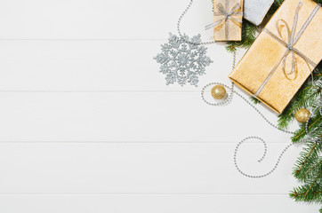 Christmas background frame top view on white wooden plank table background with copy space around products. Presents and decorations isolated on white. Horizontal and diagonal composition.
