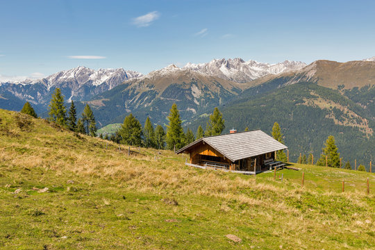 Wooden shepherd lodge with Alpine mountain landscape in Austria.