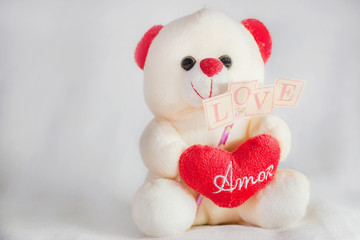 Love teddy bear holding a love heart and a love sign 