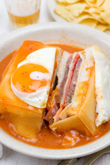 traditional portuguese sandwich with sauce francesinha on dish