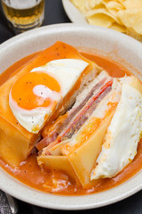 traditional portuguese sandwich with sauce francesinha on dish