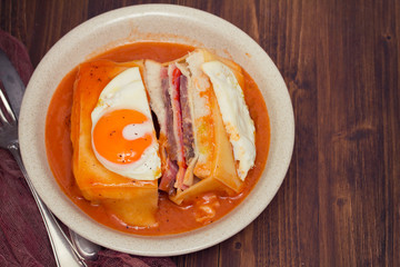 traditional portuguese sandwich with sauce francesinha on dish