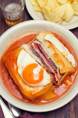traditional portuguese sandwich with sauce francesinha on dish