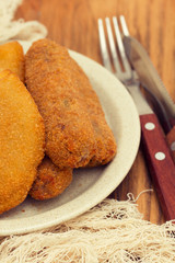 meat croquettes on paper on wooden background