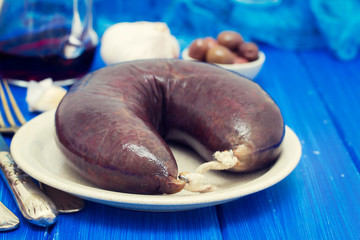 smoked blood sausage on white dish on wooden background