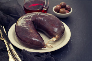 smoked blood sausage on white dish on wooden background