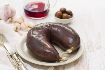smoked blood sausage on white dish on wooden background