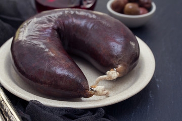 smoked blood sausage on white dish on wooden background