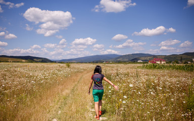 girl walking in a yellow field in Ukrainian Carpathians