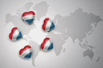 five hearts with national flag of luxembourg on a world map background.