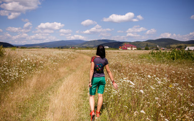 girl walking in a yellow field in Ukrainian Carpathians