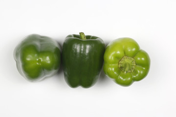 three green peppers on white background.