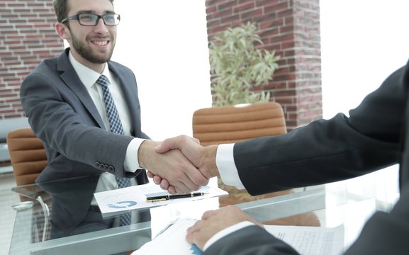 financial partners handshake after signing contract