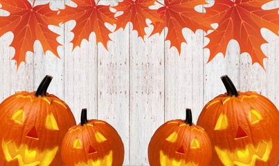 Autumn carved pumpkin pumpkin with yellow leaves on a wooden background - 181540859