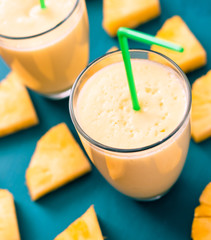 sliced pineapple with a glass of pineapple juice on a blue wooden background