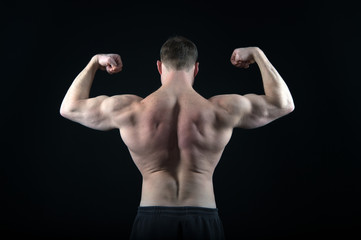 Fototapeta na wymiar Athletic bodybuilder pose in pants isolated on black background.