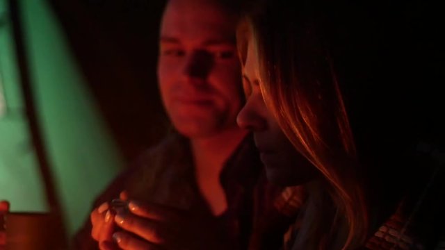 Lovely couple dreaming at night campfire light