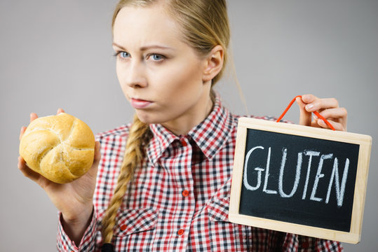 Woman holding board with gluten sign and bun bread